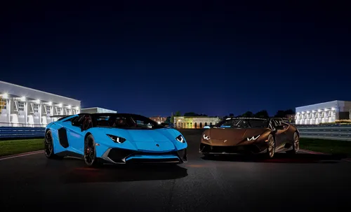 Lamborghini Huracan Обои на телефон пара спортивных автомобилей, припаркованных на улице со зданиями на заднем плане