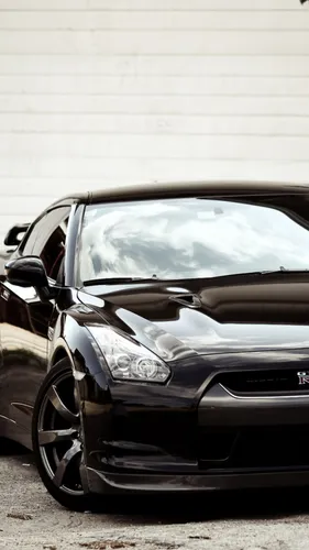 Nissan Skyline Обои на телефон черный автомобиль, припаркованный перед белой стеной