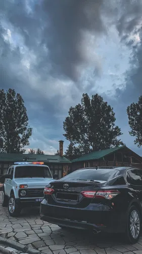 Toyota Camry Обои на телефон пара машин, припаркованных перед домом с большим облаком дыма