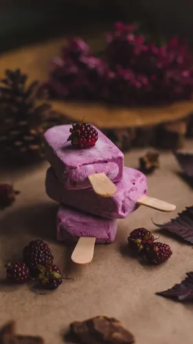 Вкусные Обои на телефон фиолетовый торт с белой глазурью и красными ягодами на белой поверхности