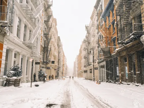 Новогодний Нью Йорк Обои на телефон заснеженная улица со зданиями по обе стороны от нее