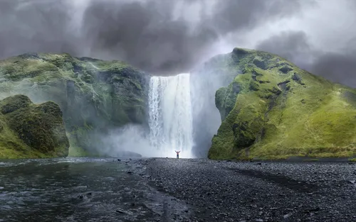 Водопад Горы Обои на телефон человек, стоящий на скалистом берегу с водопадом и водоемом внизу