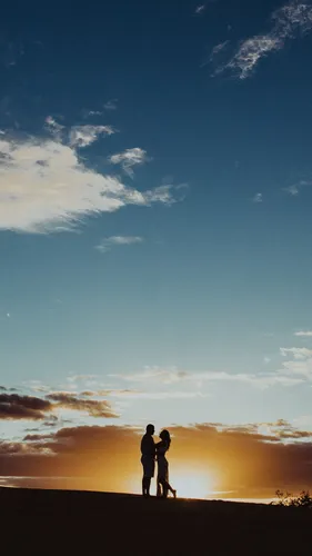 Романтика Обои на телефон мужчина и женщина, стоящие на пляже с заходящим солнцем