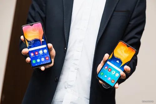 Самсунг А20 Обои на телефон человек, держащий пару сотовых телефонов