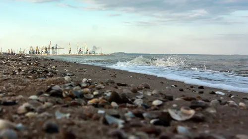 Моря Фото каменистый пляж с водоемом и группой лодок