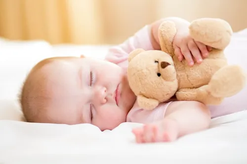 Потница Фото ребенок, лежащий на кровати с чучелом