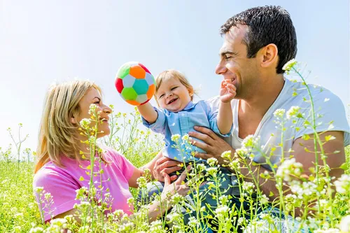 Нервная Крапивница Фото человек и пара детей играют с мячом на травянистом поле