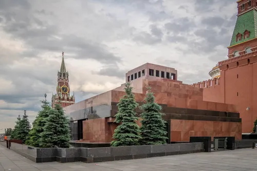 большое здание с часовой башней с мавзолеем Ленина на заднем плане