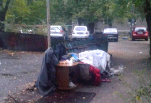 Бомжей Фото человек, сидящий на мусорном баке