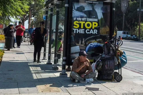Бомжей Фото человек, сидящий на тротуаре рядом с коляской