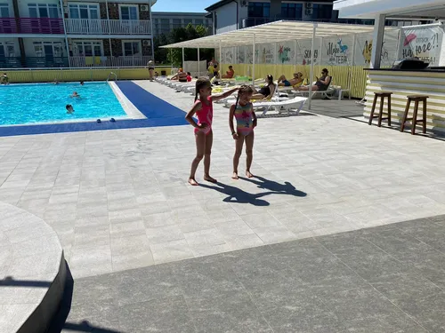 Анапа Фото две девушки в одежде стоят на каменном патио у бассейна