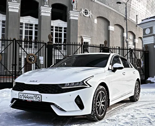 Киа К5 Фото белый автомобиль, припаркованный в снегу