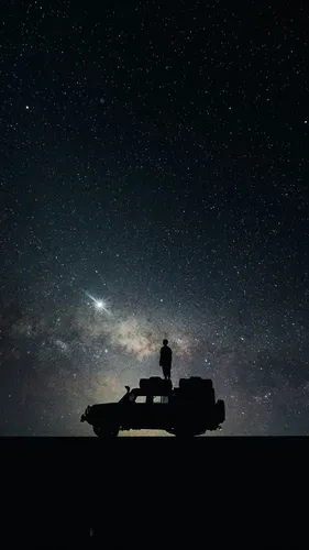 Качественные Обои на телефон человек, стоящий на транспортном средстве в ночном небе