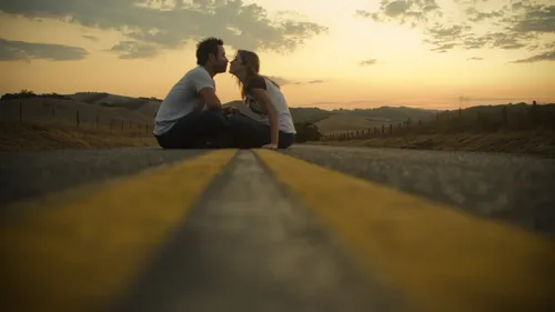 Любовь Пара Обои на телефон мужчина и женщина сидят на большом желтом круглом предмете на фоне заката